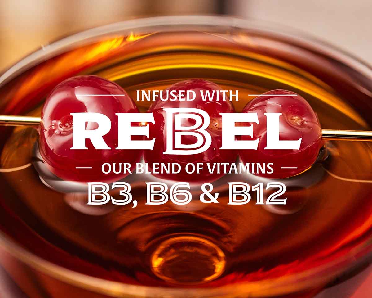Close-up of a cocktail with cherries and text about vitamins B3, B6, and B12 infused into it.