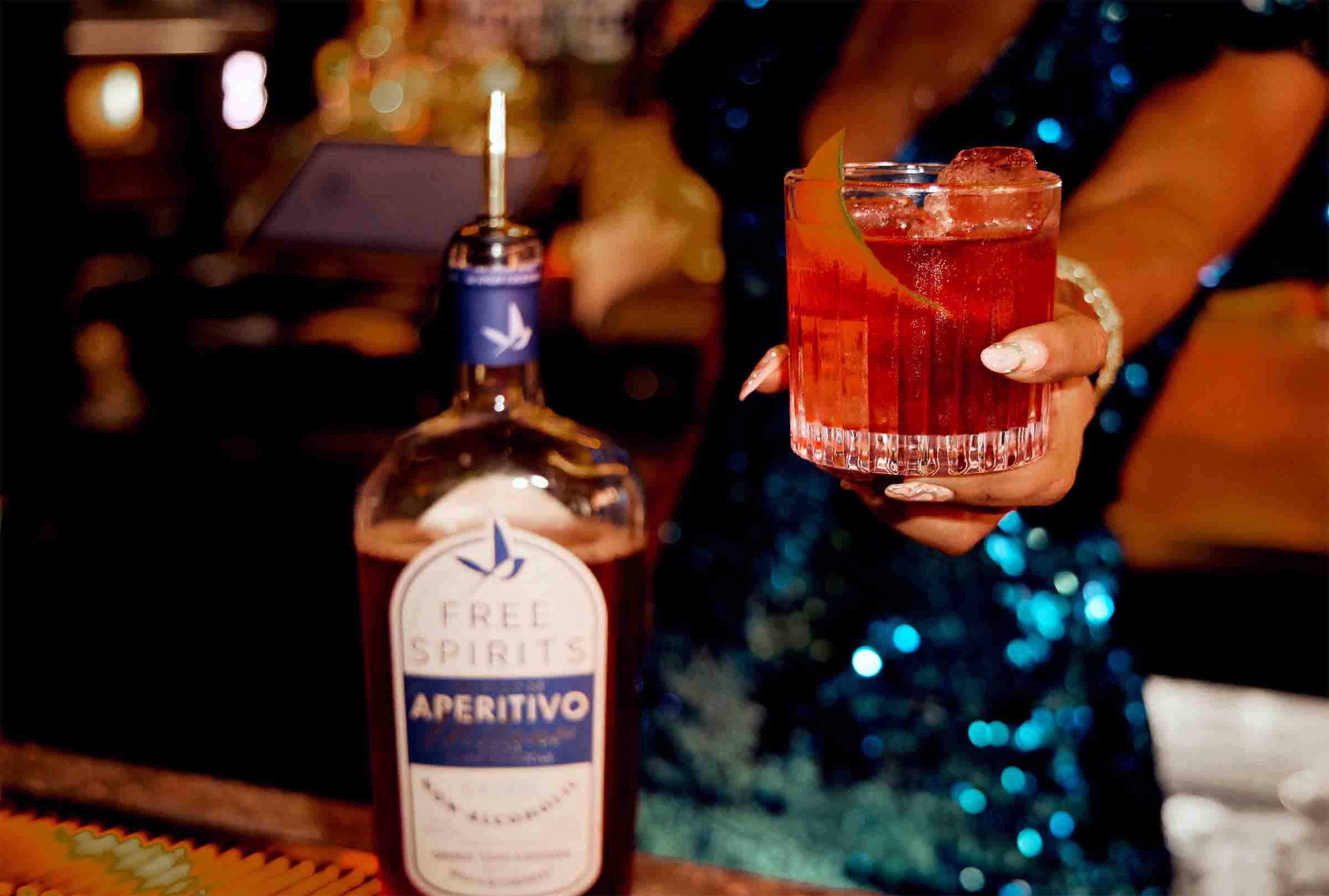 A bartender holding a cocktail made from Free Spirits