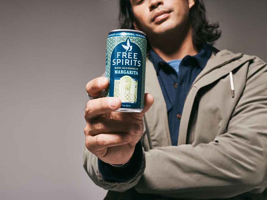 Person holding a can of Free Spirits non-alcoholic margarita against a neutral background
