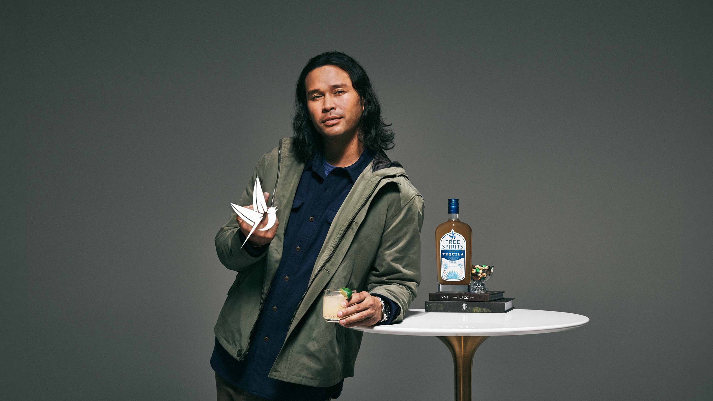 Man giving the bird to the camera leaning on a table with Free Spirits