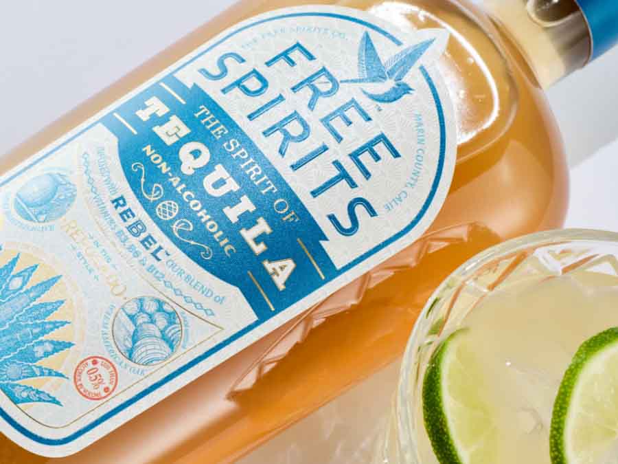 Bottle of Free Spirits non-alcoholic tequila with a glass of lime garnished drink.