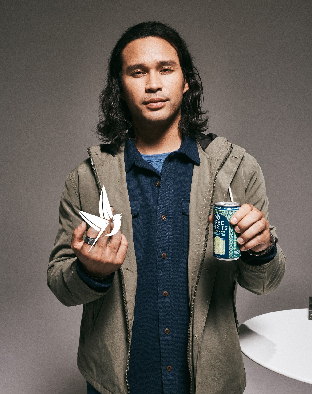 Man holding a can and giving the bird, with the Free Spirits bird obscuring his finger