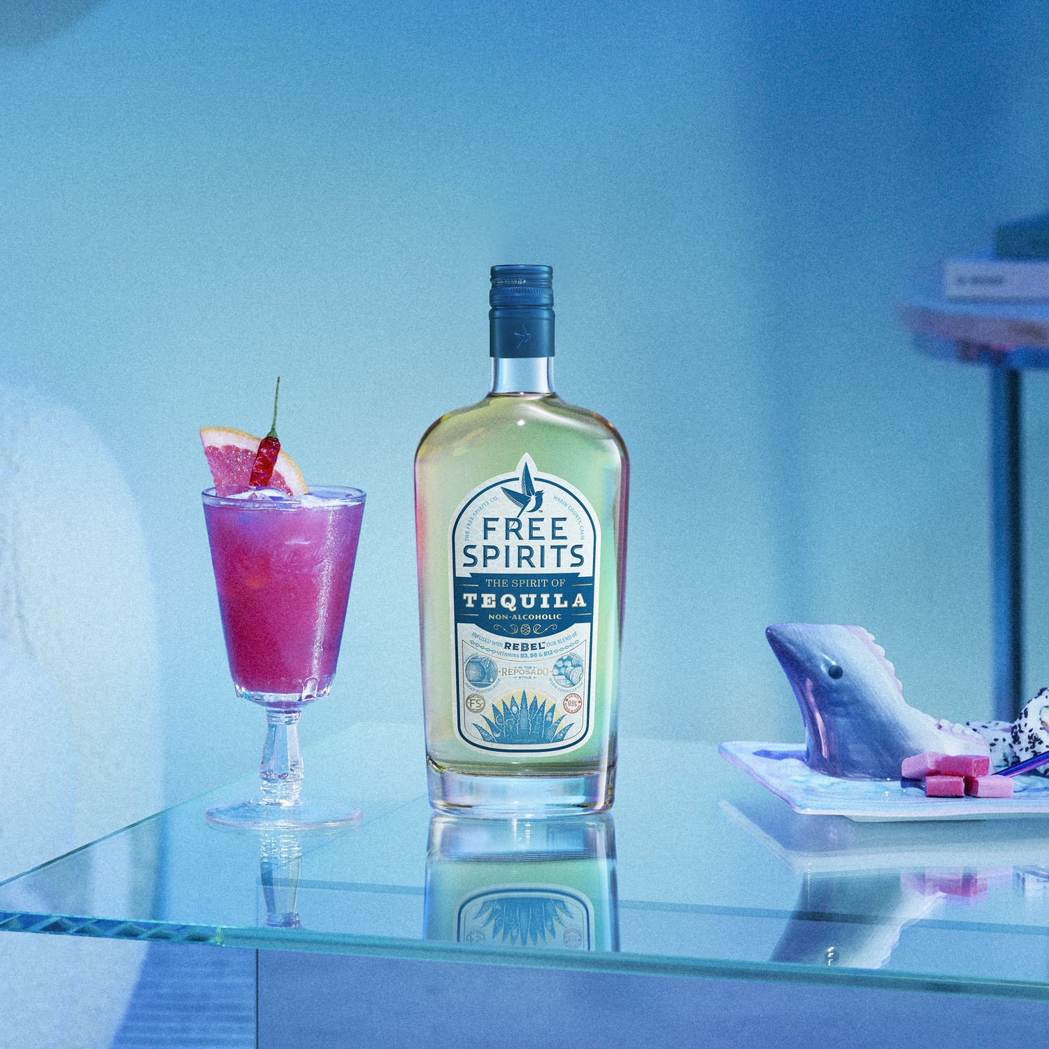 Bottle of Free Spirits tequila with a cocktail on a glass shelf