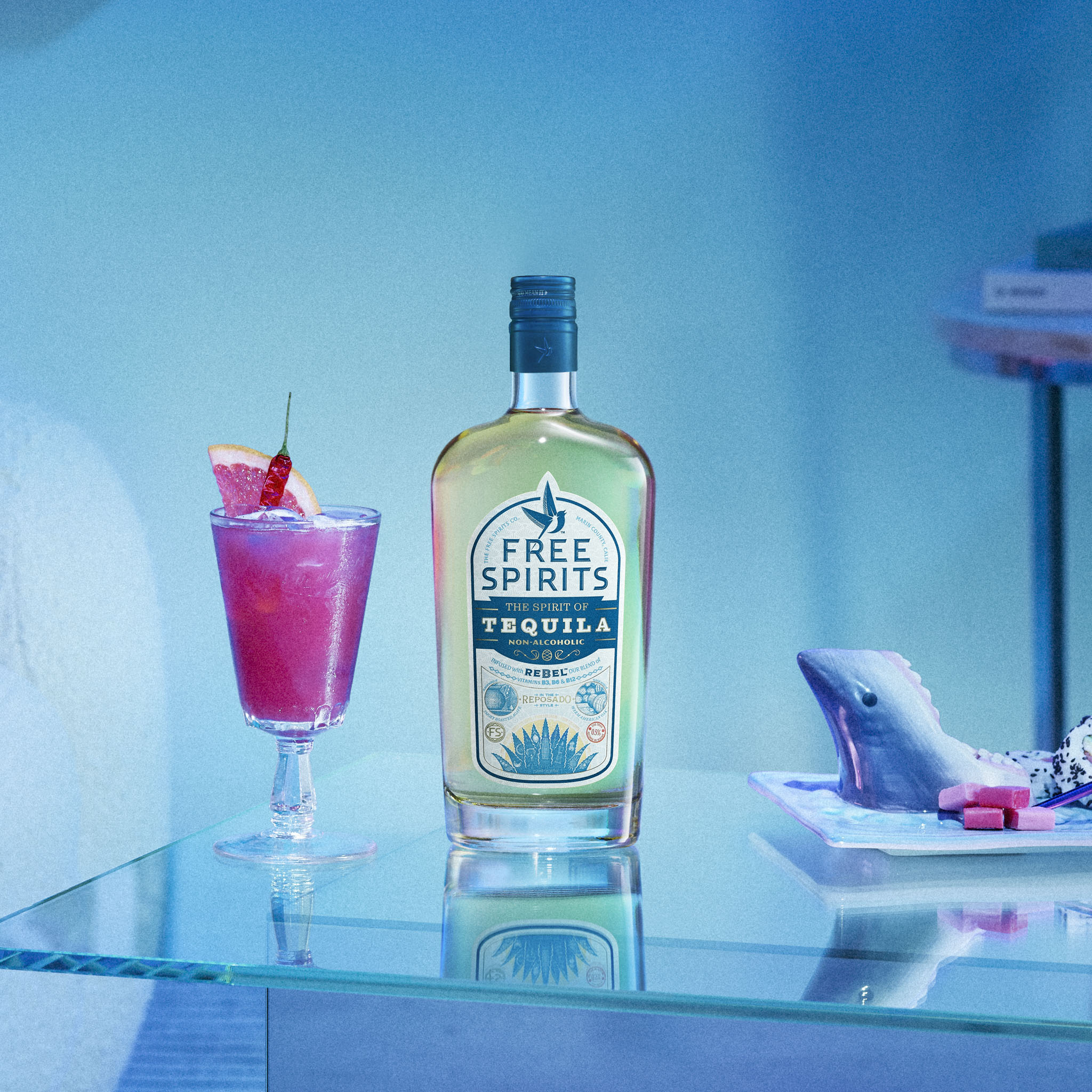 Bottle of Free Spirits tequila with a cocktail on a glass shelf