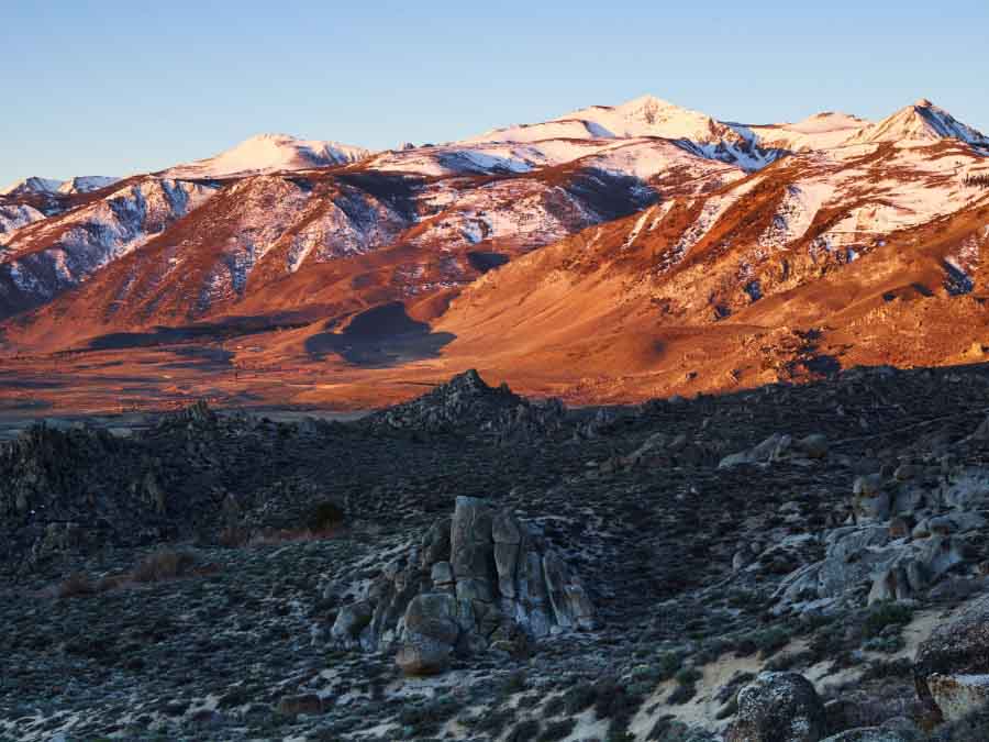 Scenic view of mountains with snow caps and a desert landscape.